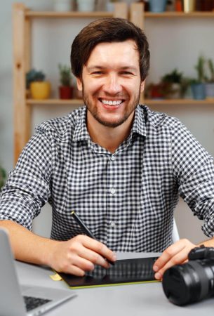 young-man-photographer-sits-at-table-and-works-fro-2025-02-24-20-05-58-utc.jpg